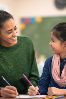 teacher and student talking abotu reading holding pencils