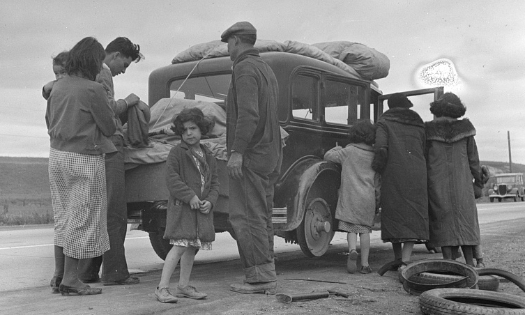 Mexican American family stands beside a packed car during the Great Depression, preparing to relocate. Labeled “voluntary” departure, but driven by joblessness, harassment, and anti-immigrant fear. Photo by Dorothea Lange, Library of Congress.